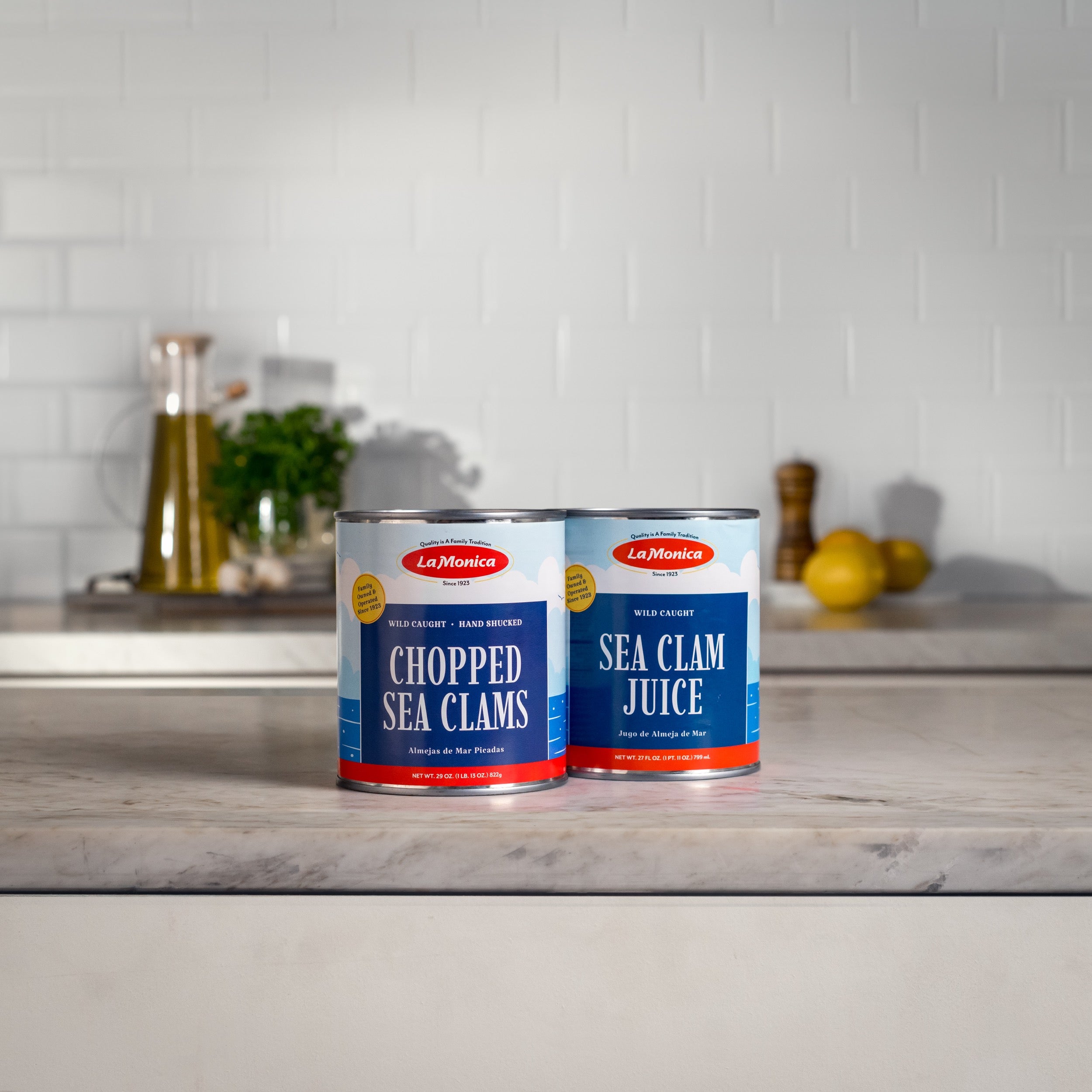 Two cans of LaMonica products on a counter with a white tile background