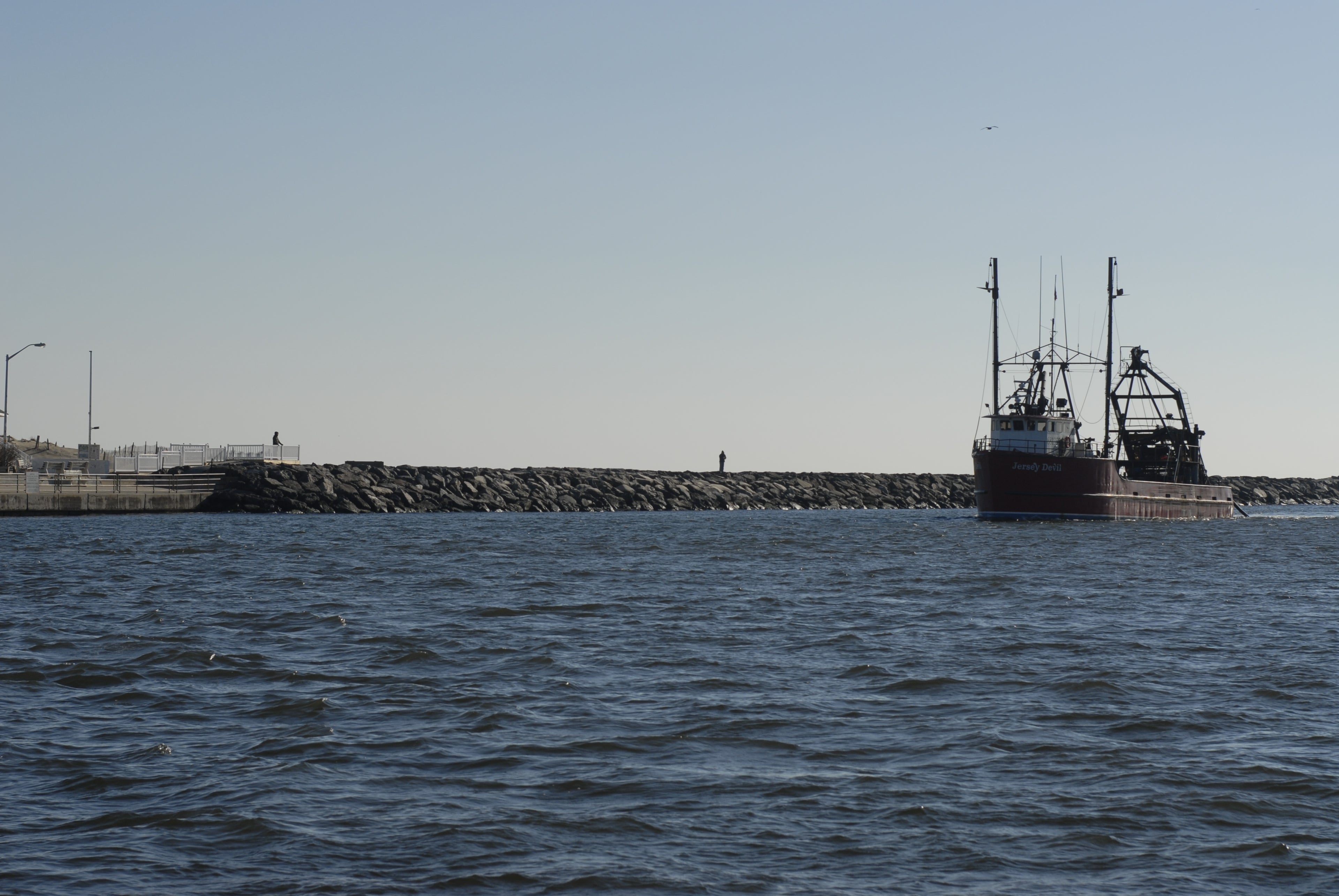 Boat arriving at harbor on blue water